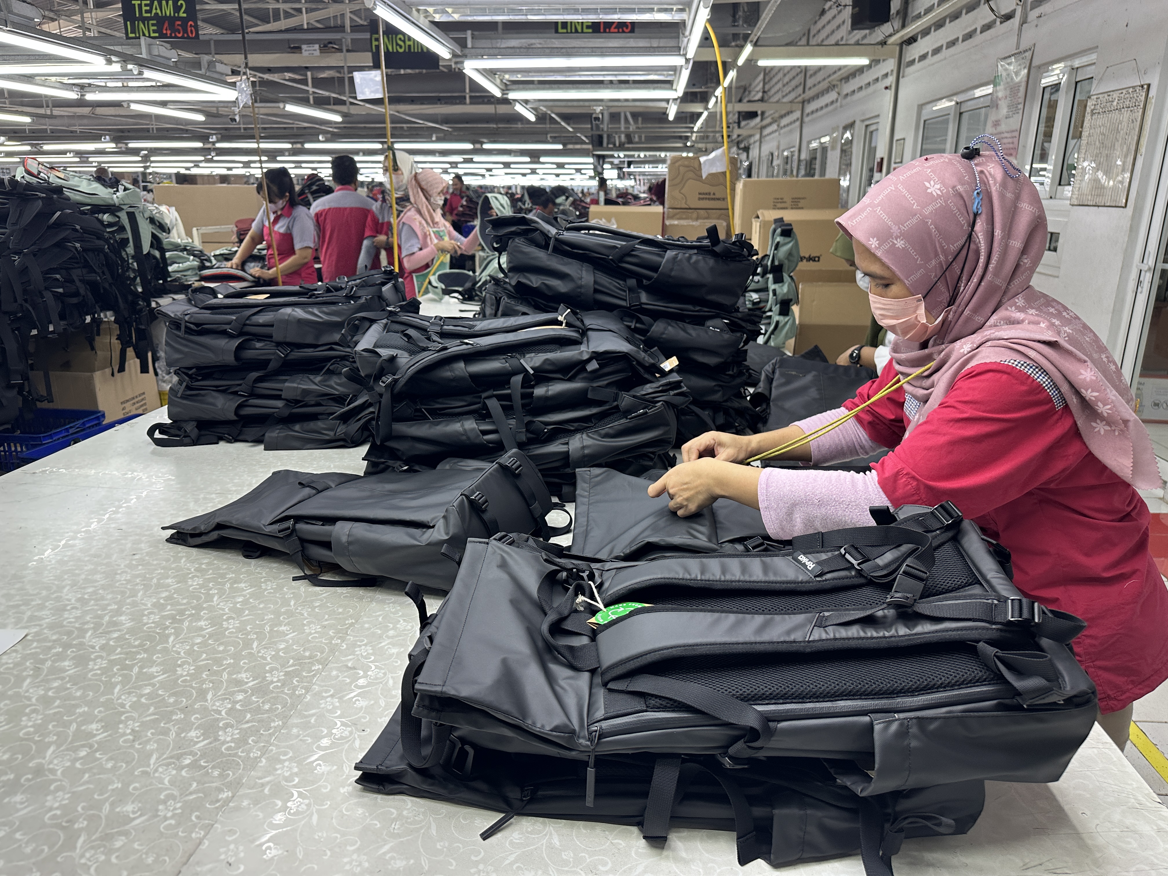Skilled worker assembling bags on the production line