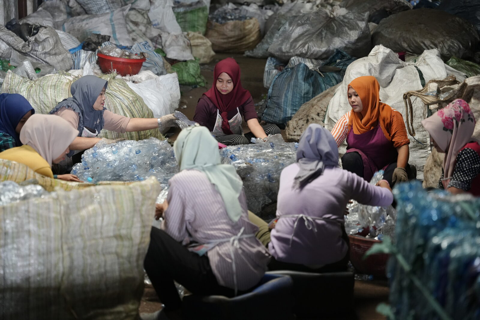 Workers sorting recycled materials at processing plant